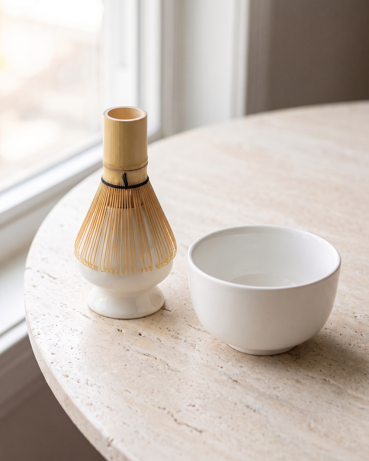 In use: Glossy Ceramic Whisk Holder – White, bamboo whisk resting prongs-down on the holder to dry