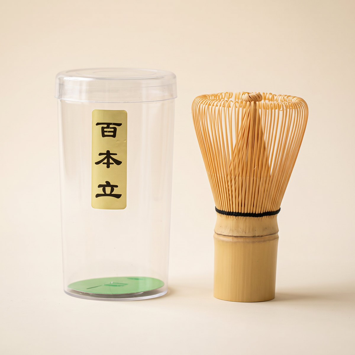 What arrives: the 100-prong whisk beside its clear protective tube, which carries a paper label with the prong count