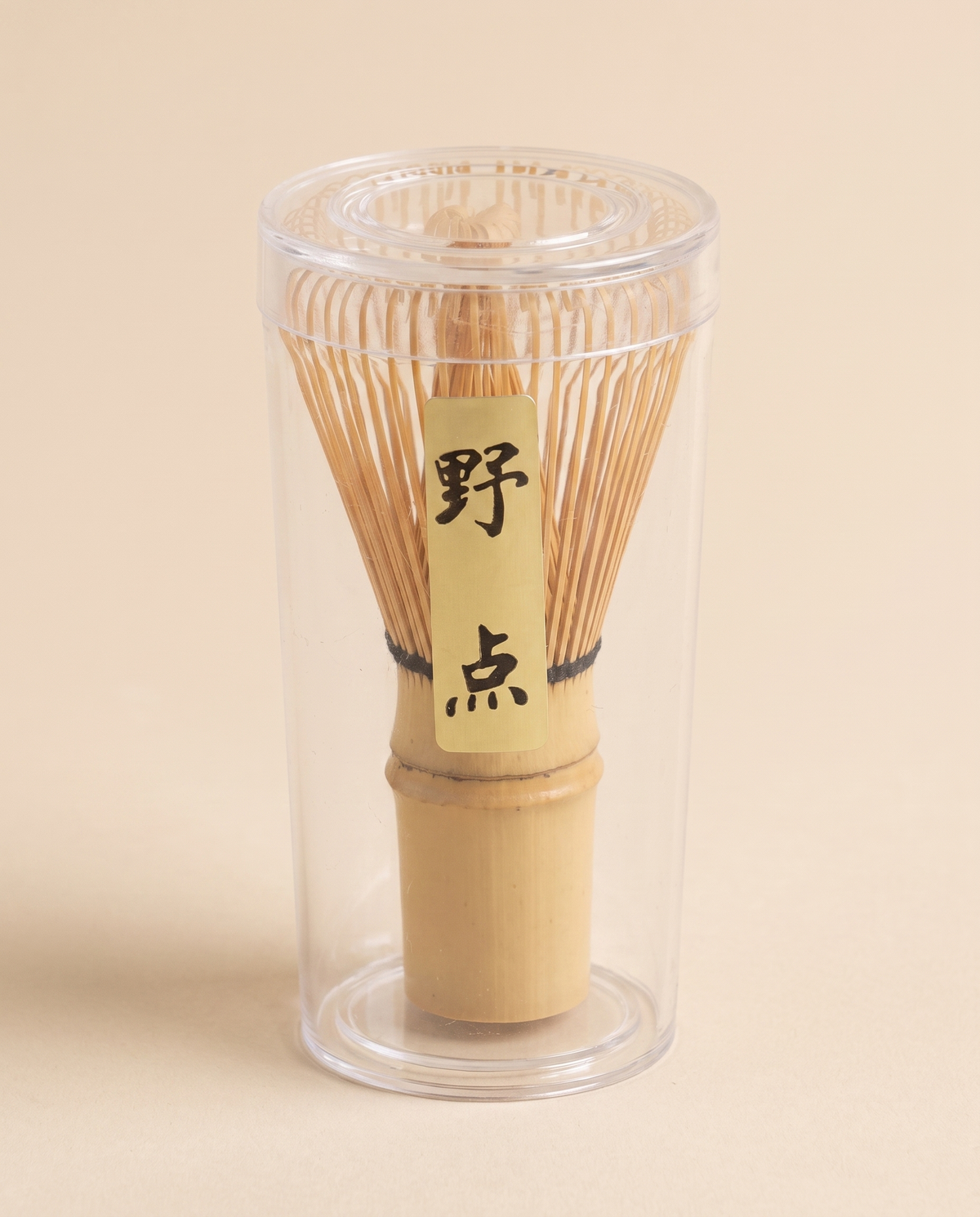 What arrives: the whisk in its clear protective tube, with the maker's paper label on the handle