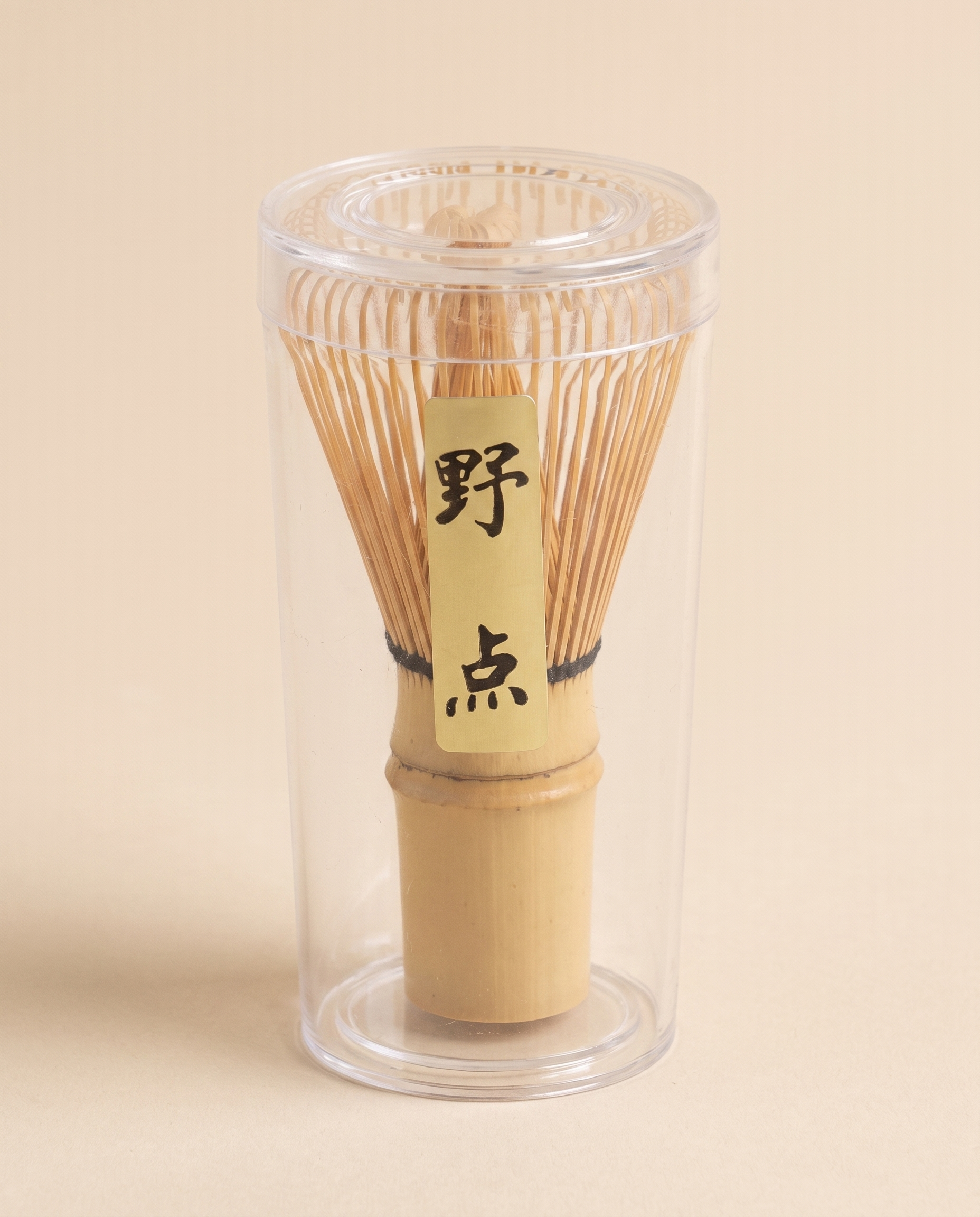 What arrives: the whisk in its clear protective tube, with the maker's paper label on the handle