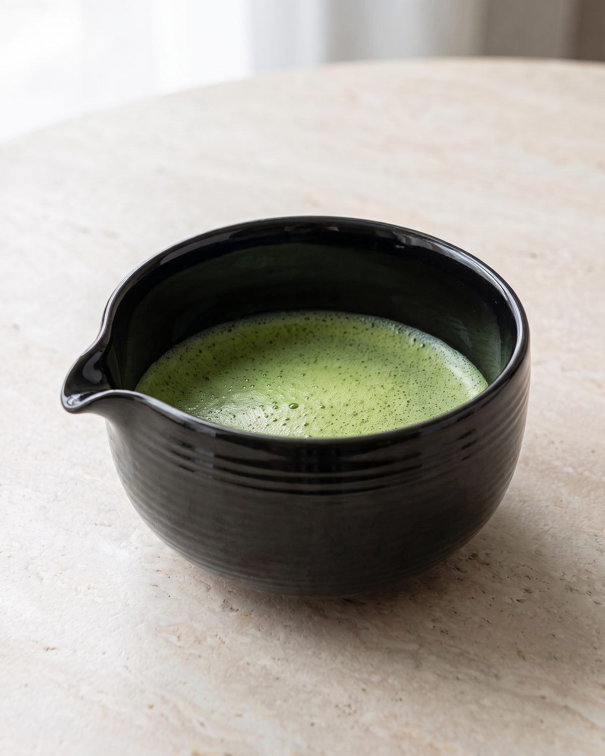 In use: Glazed Matcha Bowl 550 ml – Black, filled with freshly whisked matcha