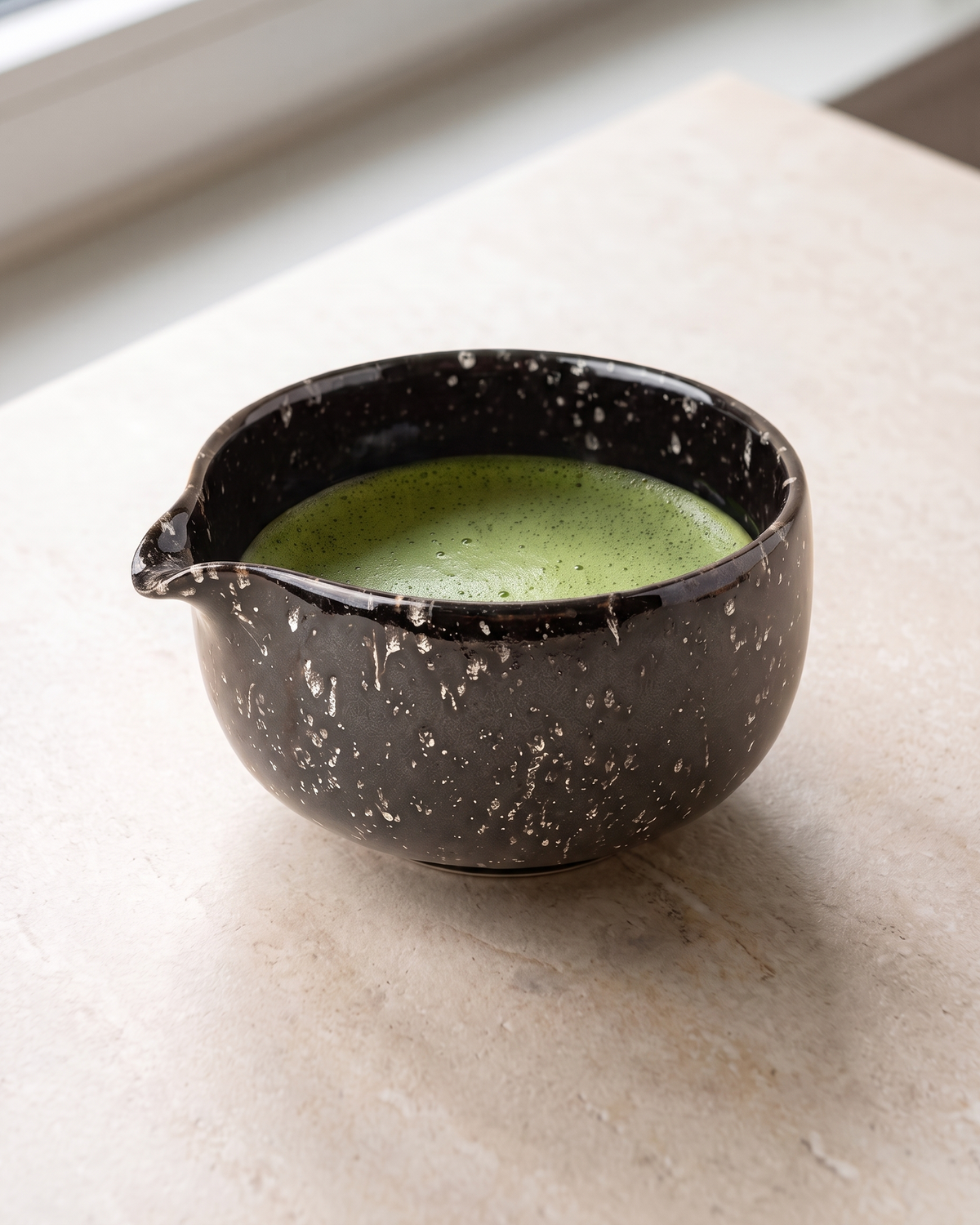 In use: Patterned Ceramic Matcha Bowl – Speckled Black, filled with freshly whisked matcha