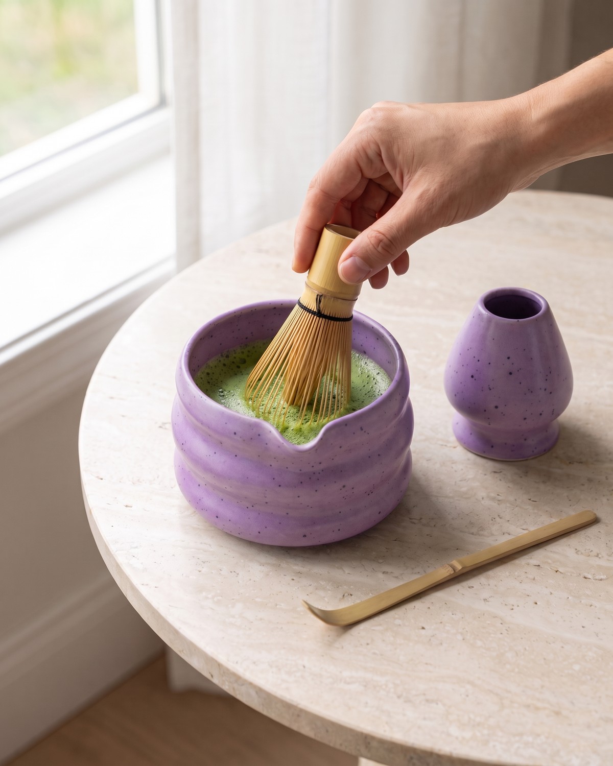In use: 4-Piece Speckled Matcha Set with Bowl, Whisk, Holder & Scoop – Purple, hand whisking matcha in the bowl, holder and scoop beside